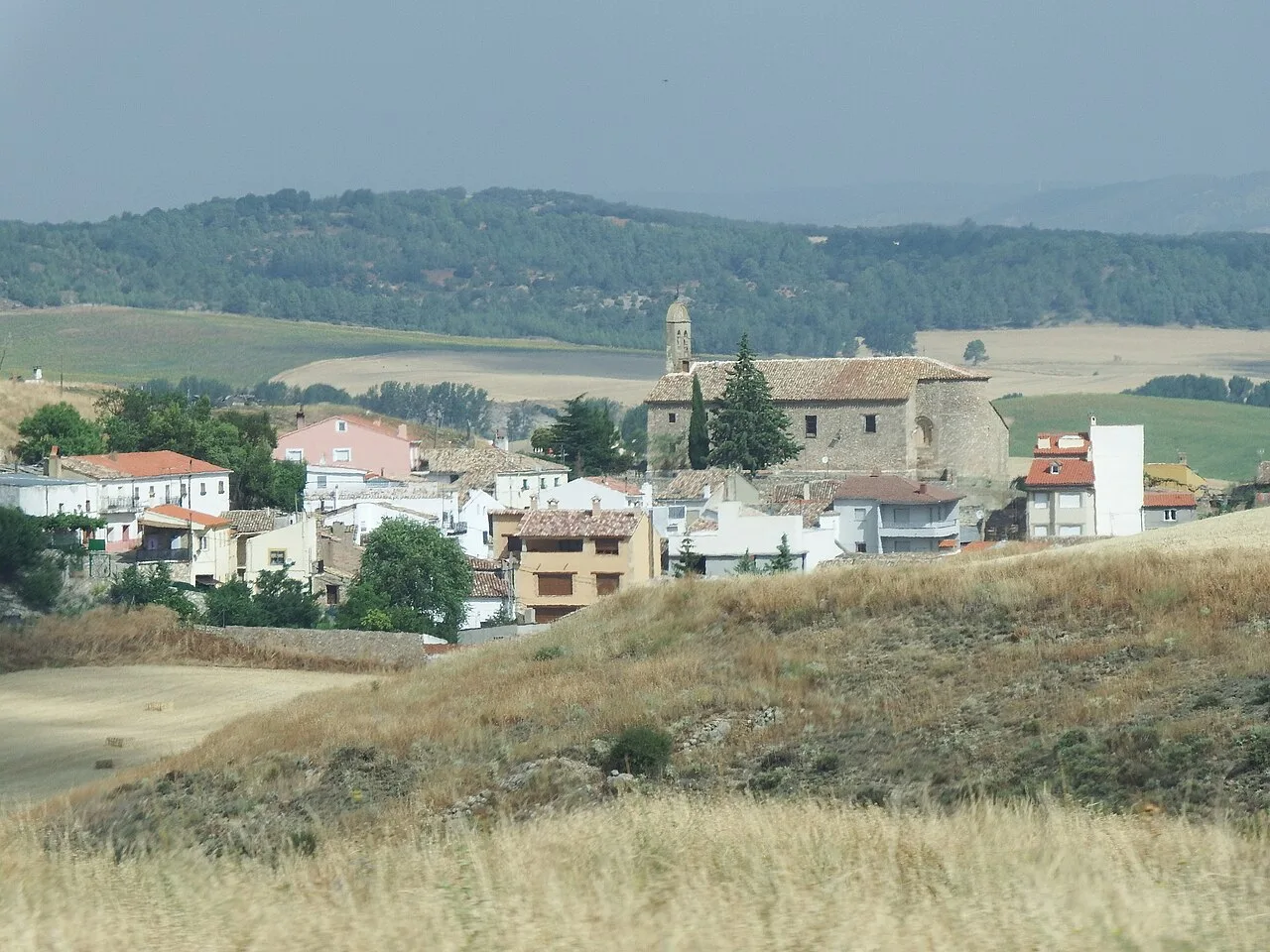 Panoramablick auf Fuentes mit Kirche und Häusern in einer ländlichen Landschaft.