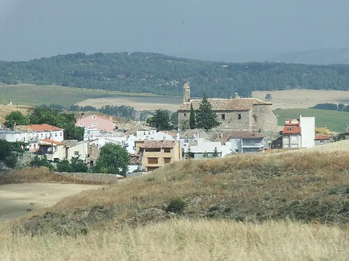 Panoramablick auf Fuentes mit Kirche und Häusern in einer ländlichen Landschaft.