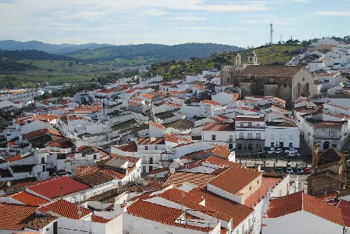 Luftaufnahme von weißen Häusern und einer Burg auf einem Hügel in Segura de León.
