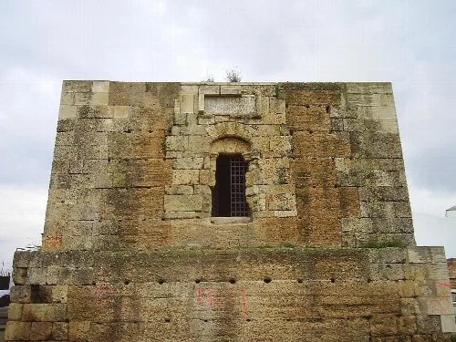 Torre de piedra con ventana de reja en Albaida del Aljarafe.