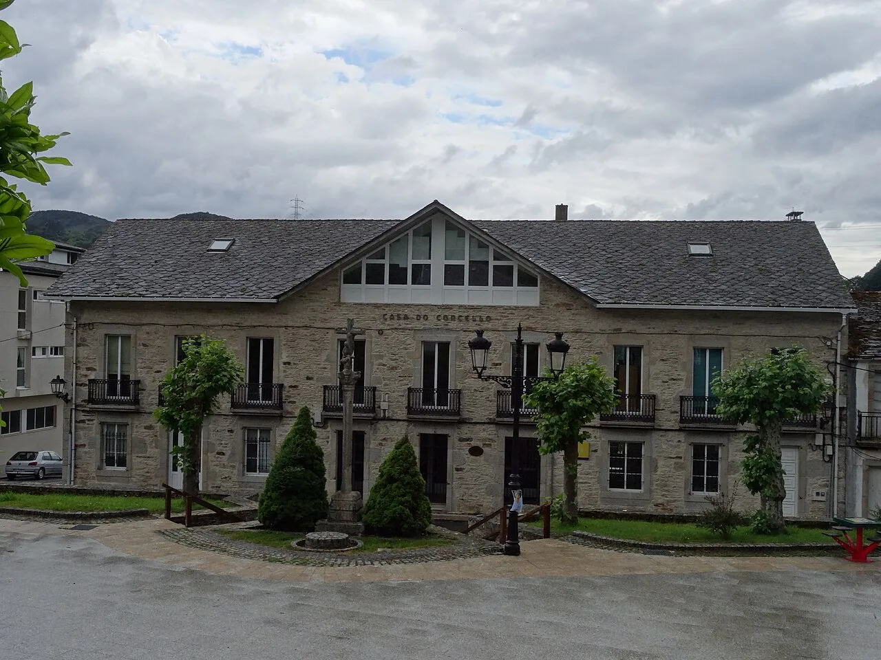 Edificio del ayuntamiento de Muras con fachada de piedra y balcones.