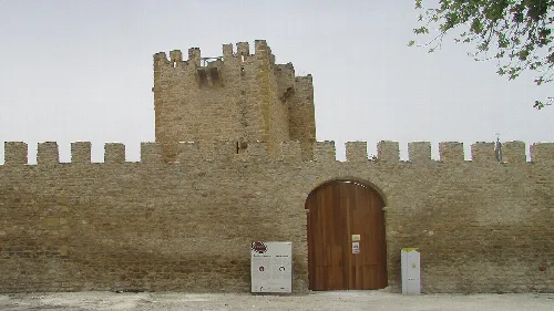 Steinmauer mit Turm und Holztür bei Lopera Castle.