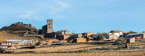 Blick auf Morón de Almazán mit Kirche und Häusern an einem sonnigen Tag.