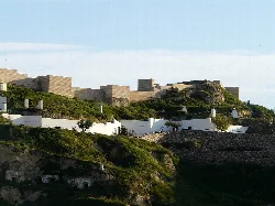 Castle on the hilltop and cave houses in the foreground in Puerto Lumbreras