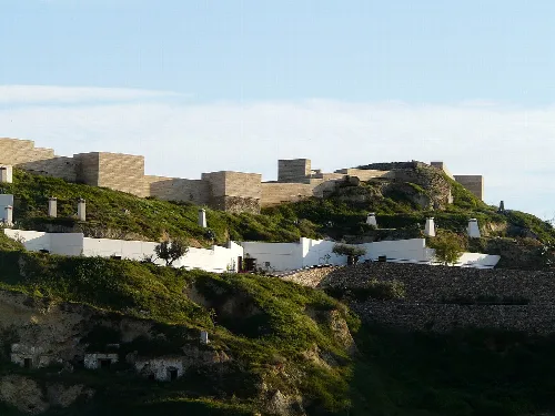 Burg auf dem Hügel und Höhlenhäuser im Vordergrund in Puerto Lumbreras