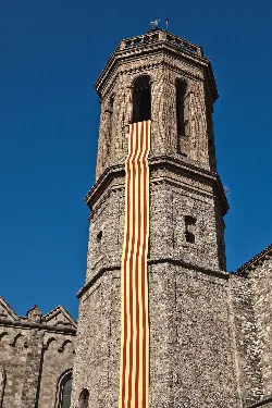 Stone tower with a Catalan flag hanging on its facade.