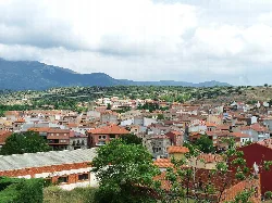 Vista de Burgohondo con casas y montañas en el fondo.