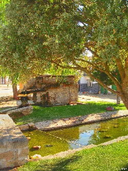 Stone fountain with water and trees in Trabanca, Salamanca.