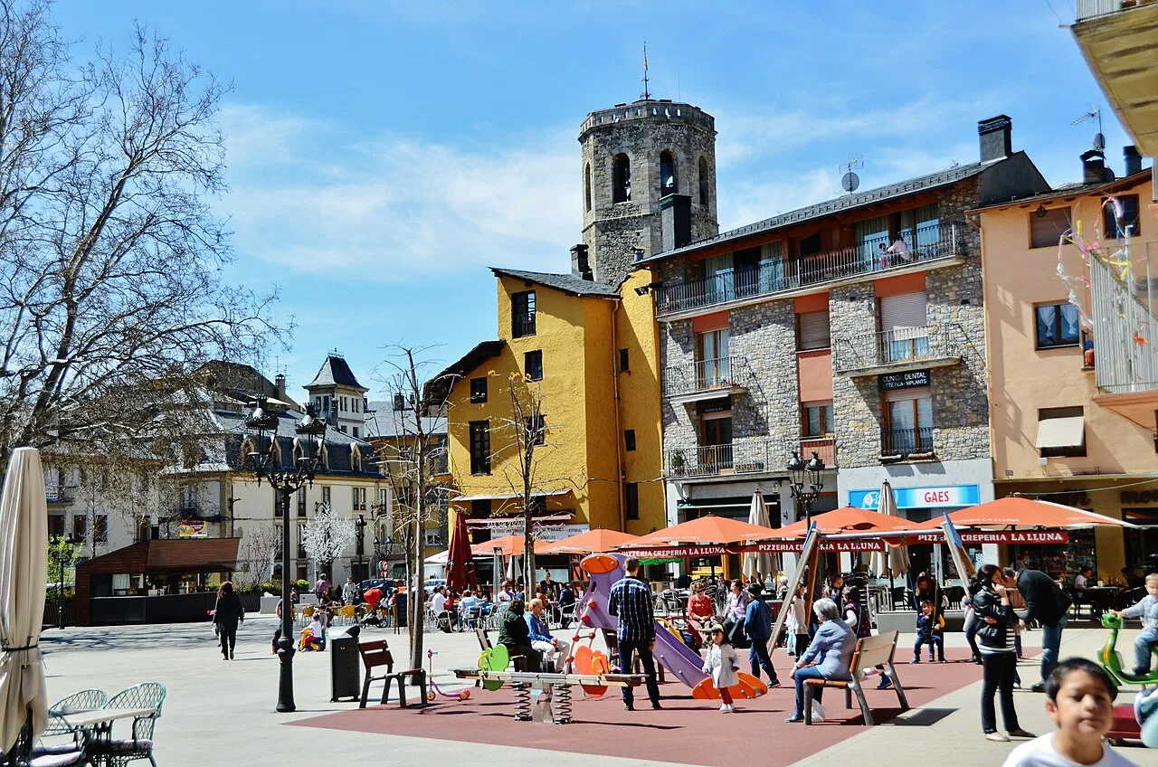 Square with tower and many people in Puigcerdà.