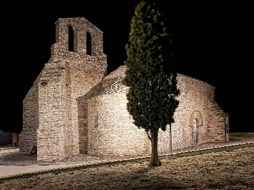 Steinkirche mit Glockenturm und Baum vor ihr in Ribera d'Ondara.