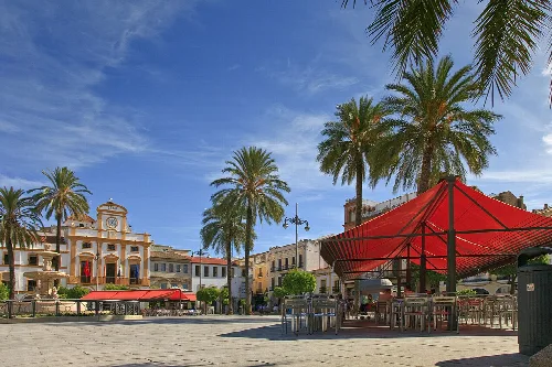 Platz mit Palmen, Terrassen und historischem Gebäude in Mérida.