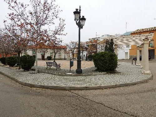 Platz mit Bäumen, Bänken und Laternen in Villar de Cañas.