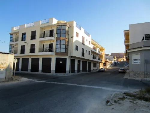 Apartment building with multiple floors and balconies in San Miguel de Salinas.