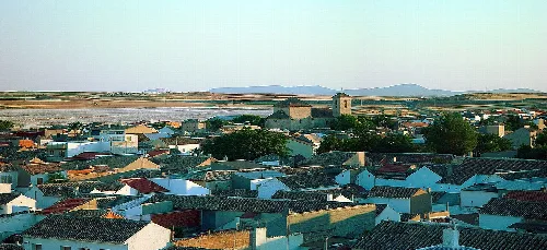 Panoramischer Blick auf Quero mit Dächern und ländlicher Landschaft.