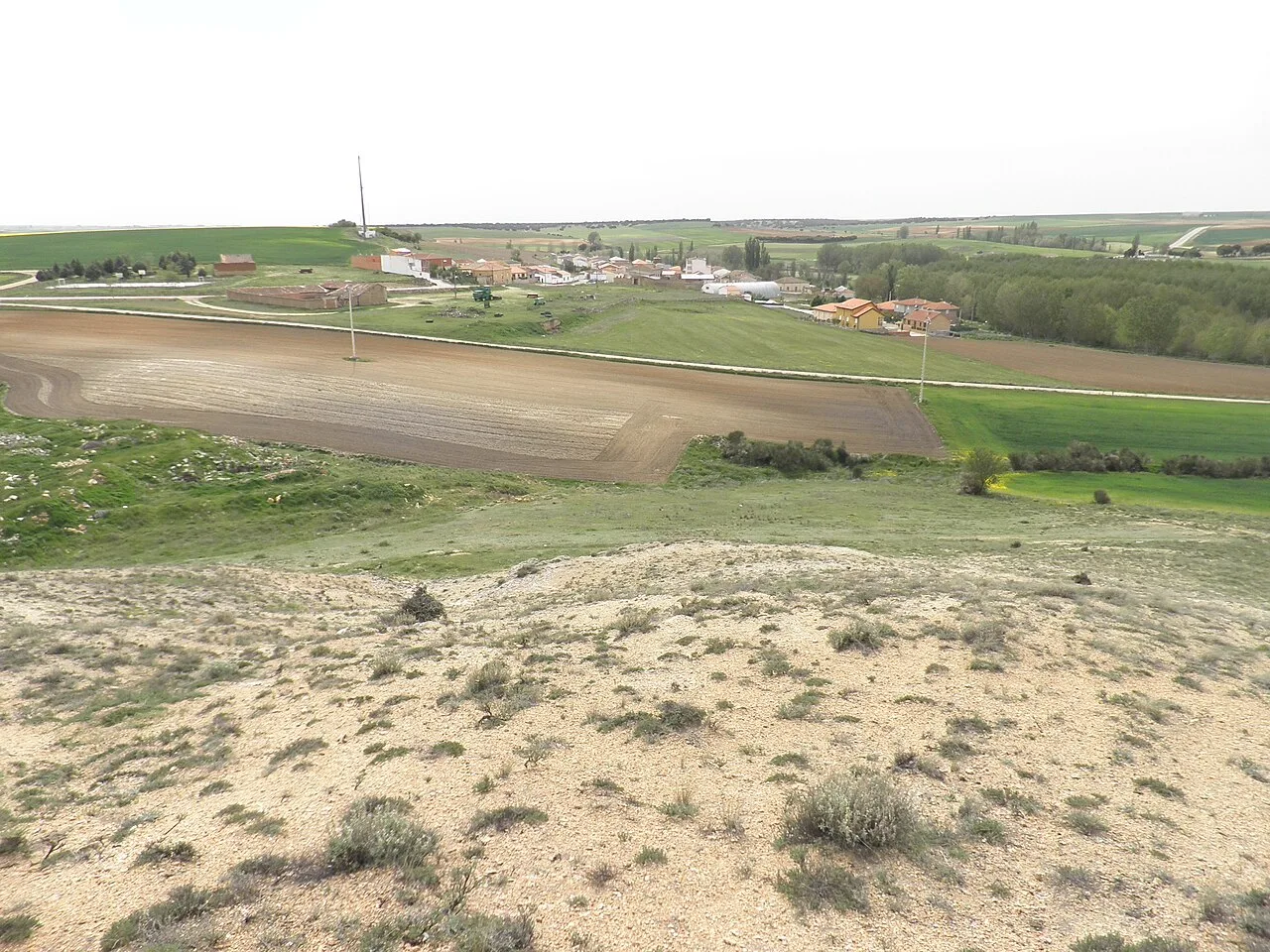 Paisaje rural con pueblo y campos desde un cerro en Vallesa de la Guareña.