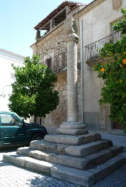 Rollo de piedra en la plaza de Zarza la Mayor con escalinata y columna.