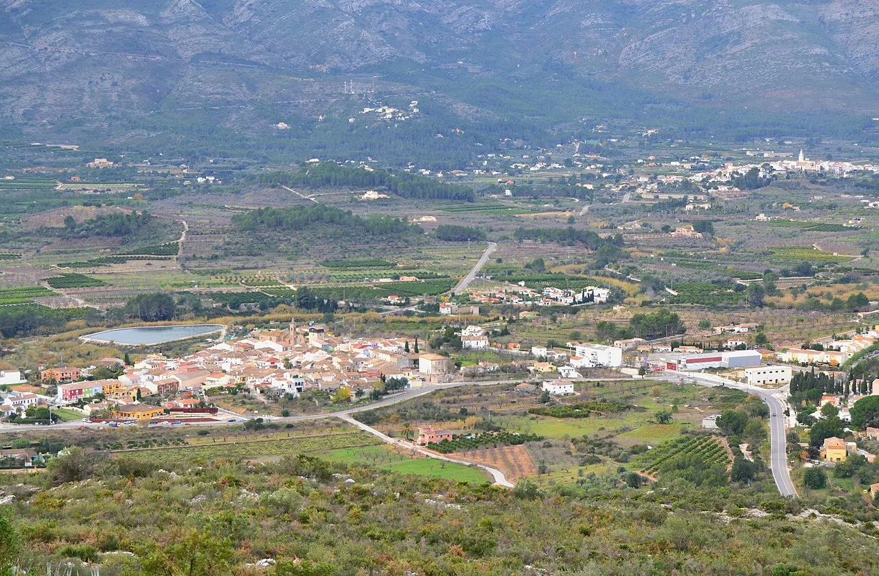 Landscape of Alcalalí with mountains and farmland.