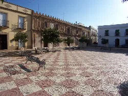 Plaza con bancos, árboles y edificios antiguos en Aceuchal.