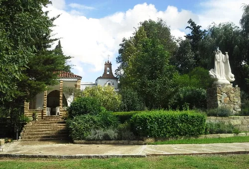 Sanctuary with stairs, trees, and a statue in the garden.