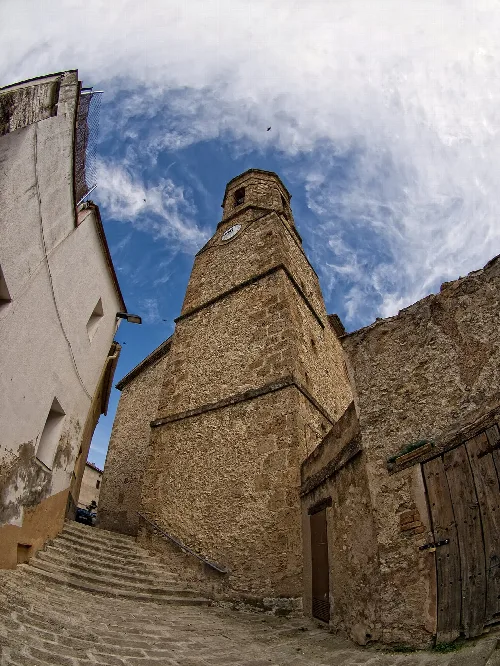 Steinerner Turm mit Uhr in Santa Margarida de Montbui, von unten gesehen.