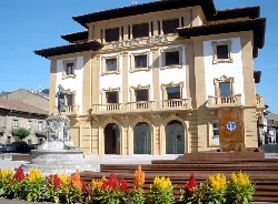 Facade of the Riera Theatre with fountain and flowers in front.