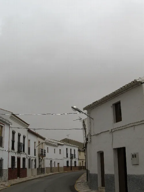 Straße mit weißen Häusern und grauem Himmel in Almargen, Málaga.