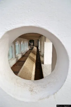 Lavadero con un canal de agua y ventanas arqueadas en la pared.