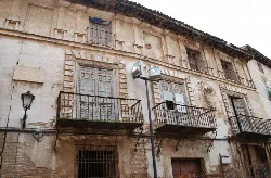 Fachada de un edificio antiguo con ventanas y balcones en Corella.