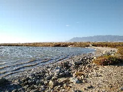 Laguna con montañas y camino de piedras en Punta Entinas-Sabinar.