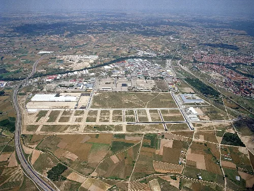 Aerial view of the city with industrial parks, roads, and neighborhoods.
