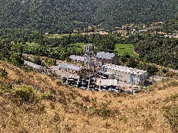 Pozo Calderón with industrial structures in a valley surrounded by vegetation.