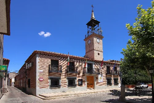 Town hall building with tower and clock in Calera y Chozas.