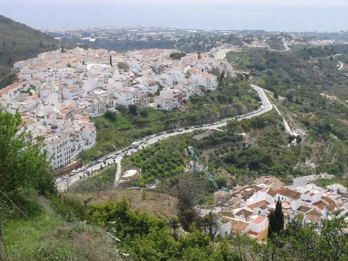 Weiße Häuser auf grünen Hügeln in Frigiliana, Málaga.