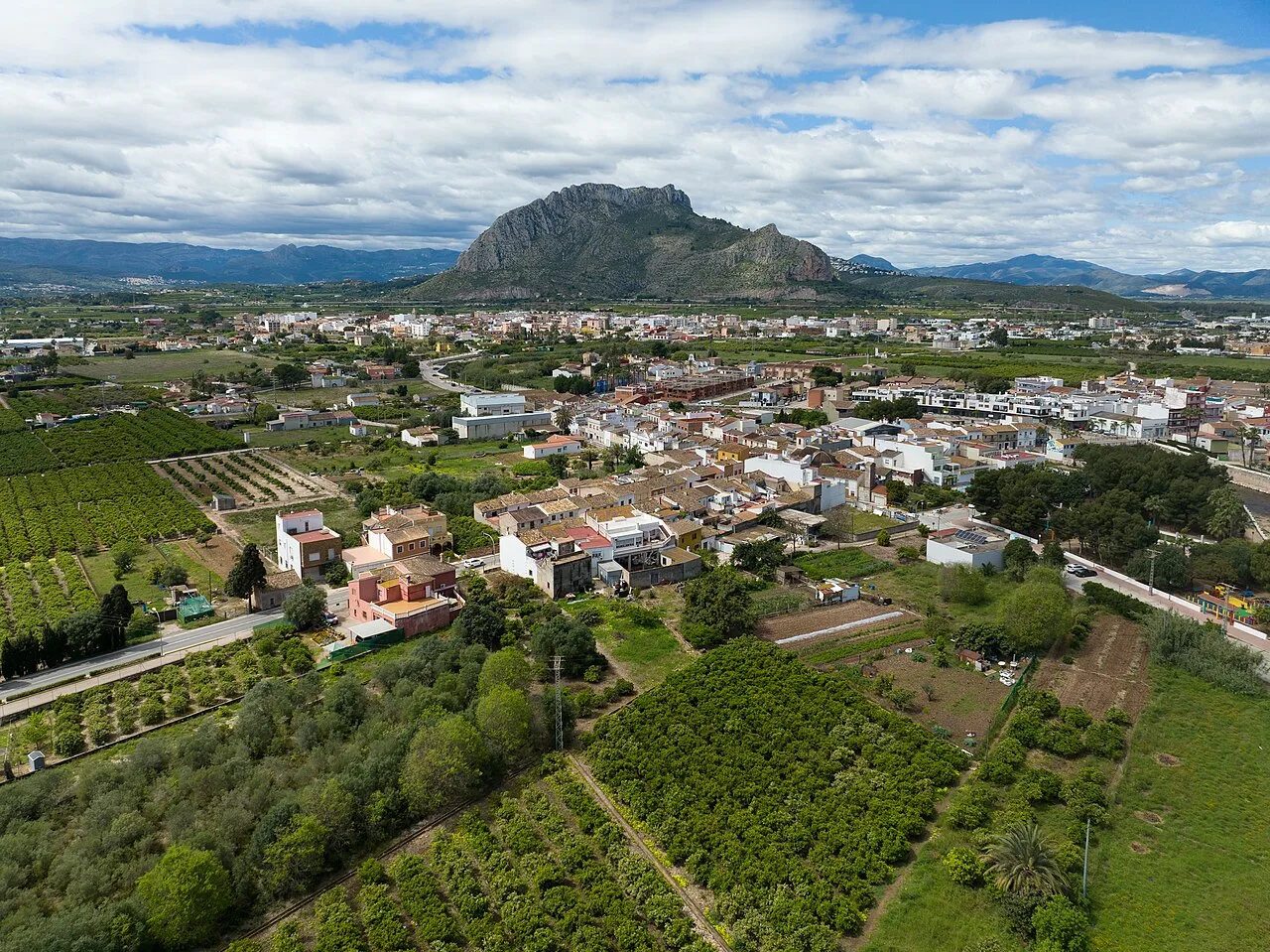 Landschaft mit Häusern, Feldern und einem Berg im Hintergrund in Els Poblets, Alicante.