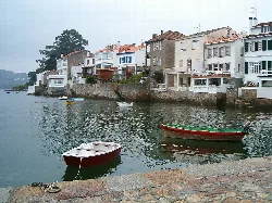 Puente de piedra y barcos en el puerto de Redes en Ares.