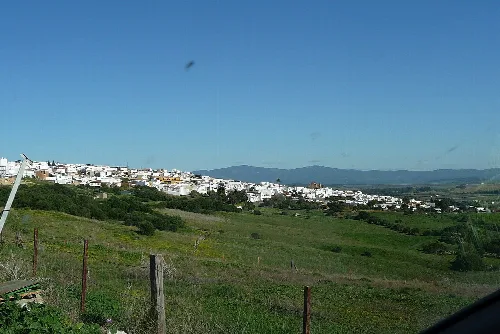 Landschaft mit weißen Häusern in Benalup-Casas Viejas und Hügeln im Hintergrund.