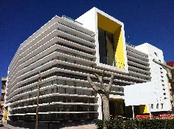 Gebäude mit weißen, geschwungenen Linien und einem gelben Rahmen an der Fassade.