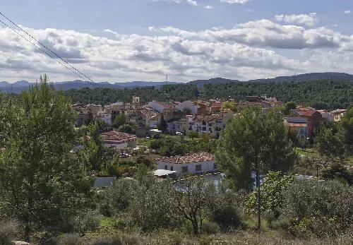 Paisaje de Benafer visto desde la Ermita de San Roque con árboles y casas.