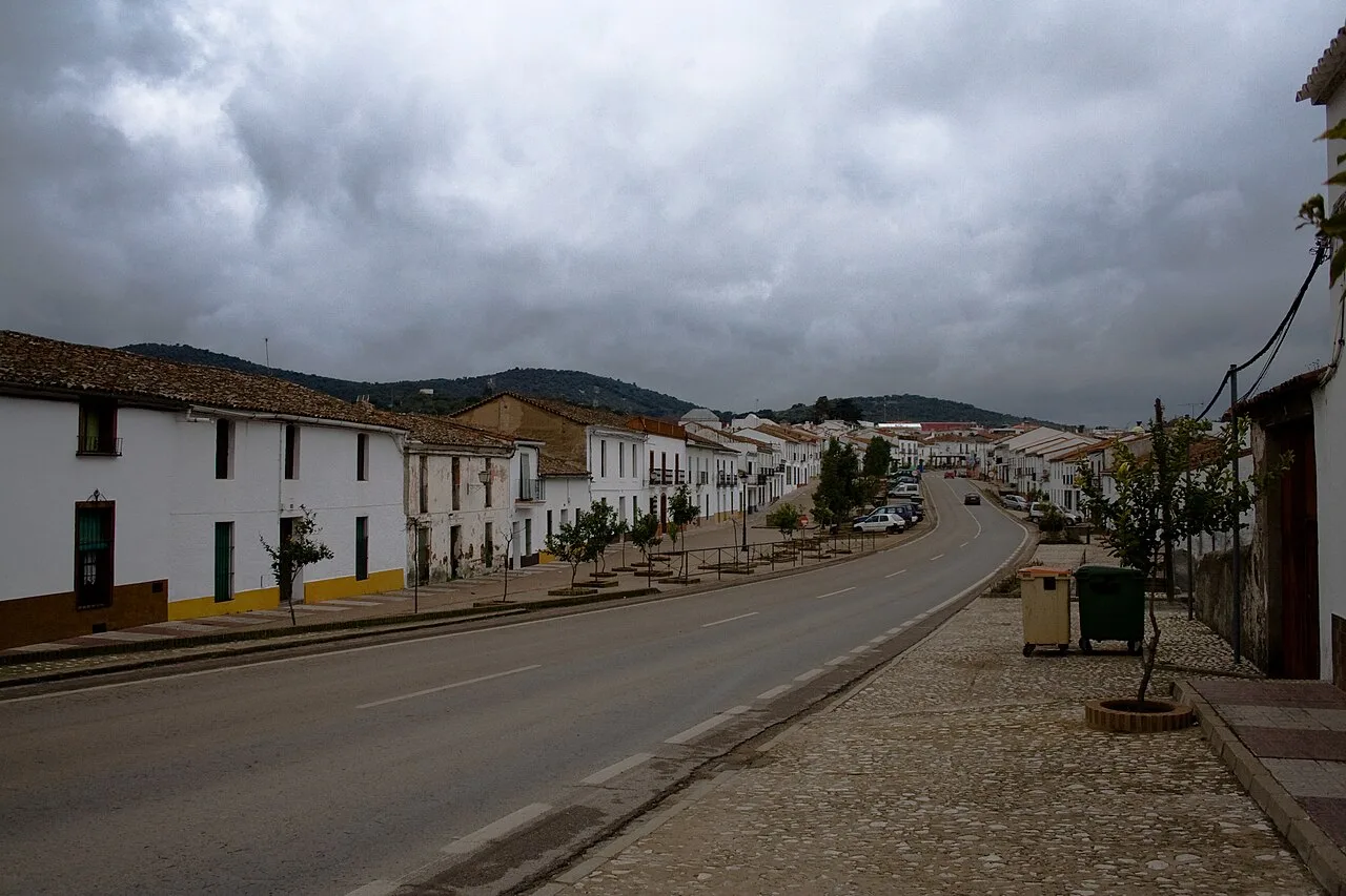 Straße mit weißen Häusern und wolkigem Himmel in Cala, Huelva.