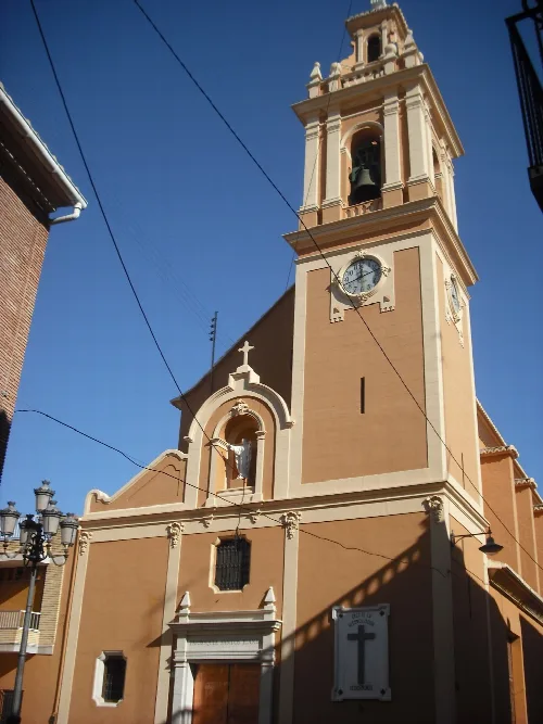 Fassade einer Kirche mit Uhr und Glockenturm in Meliana.