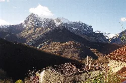 Snow-capped mountains and houses in Ponga, Asturias.