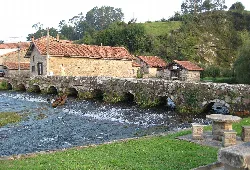 Stone bridge with nine arches over a river in Ruente, Cantabria.