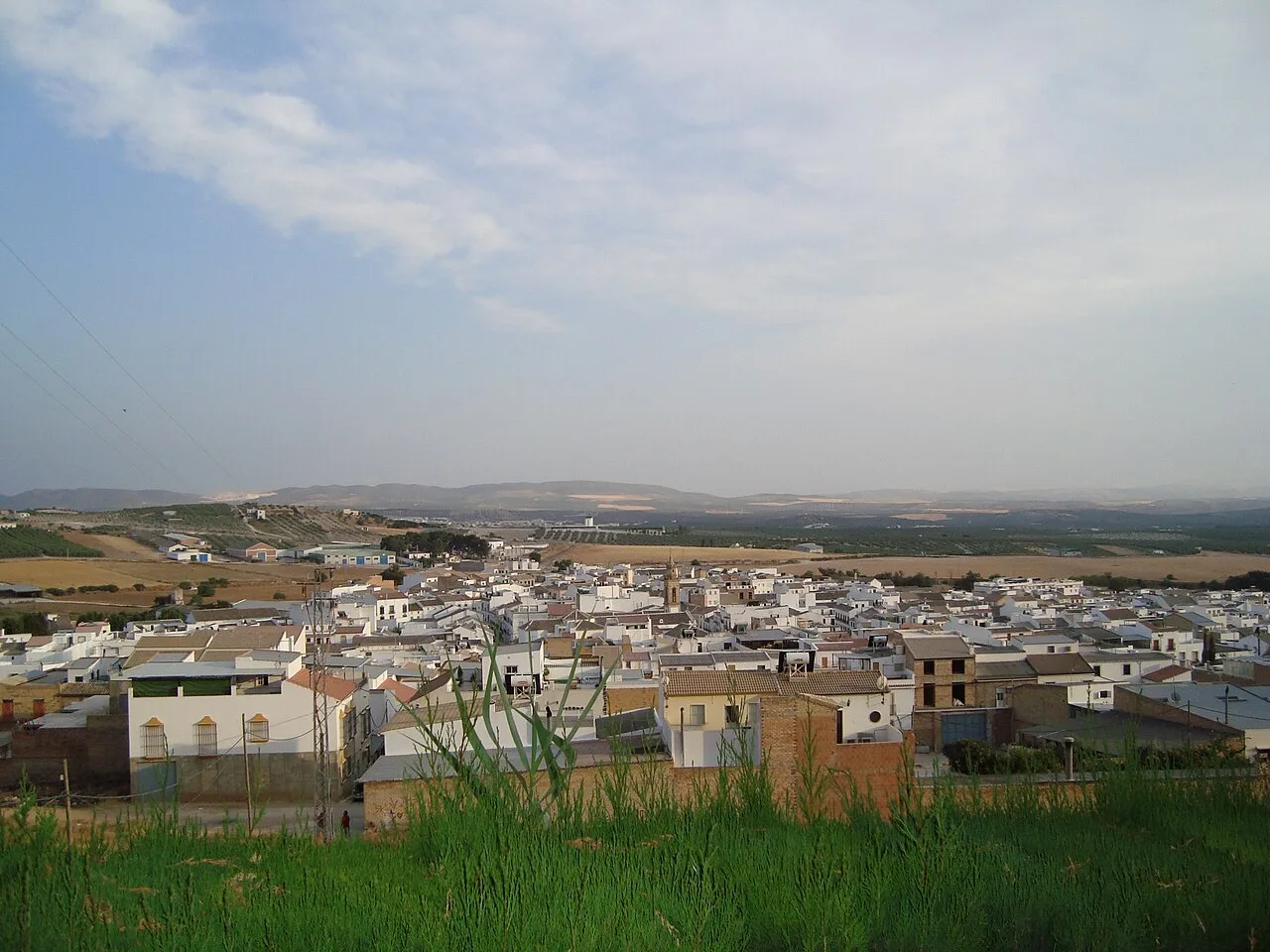 Vista panorámica de Gilena desde los jardines, con casas y campo en el horizonte.