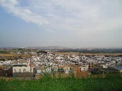 Vista panorámica de Gilena desde los jardines, con casas y campo en el horizonte.
