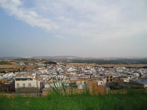 Panoramablick auf Gilena von den Gärten, mit Häusern und Feldern im Hintergrund.