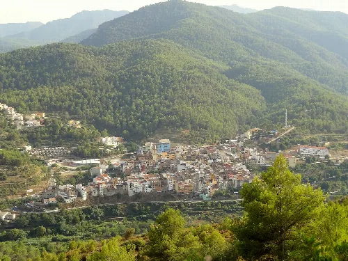 Vista panorámica de Sueras con montañas y casas en el valle.