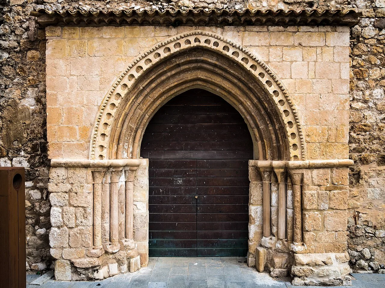 Kirchentür mit romanischem Bogen und Säulen in Alarcón.