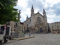 Facade of Sainte Marie Basilica with towers and rose window in Villafranca del Panadés.