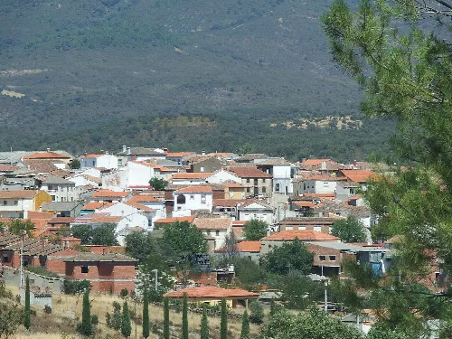 Vista de un pueblo con casas y montañas al fondo.