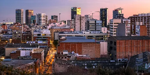Stadtansicht mit hohen Gebäuden und Wolkenkratzern bei Sonnenuntergang in Hospitalet de Llobregat.